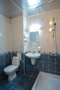 a bathroom with a toilet and a sink and a tub at Family Hotel Eliri in Nesebar