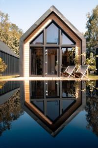 a house with chairs in a pool of water at Trzy Domki w Mielnie in Mielno