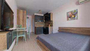 ein kleines Schlafzimmer mit einem Bett und einer Küche in der Unterkunft HostEx Pastello Deluxe Studio in Stara Sagora