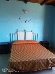 sypialnia z łóżkiem ze słowem miłość na ścianie w obiekcie Le Terrazze di Martina w mieście Nicotera
