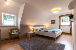 a bedroom with a bed and a chair and windows at Ferienhaus-Eschede in Eschede +64 photos