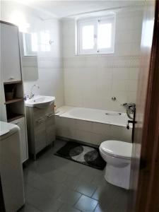 a bathroom with a tub and a toilet and a sink at Petrochori Memories House- Floor 1 in Petrochori +34 photos