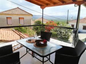 a table and chairs on a balcony with a view at Petrochori Memories House- Floor 1 in Petrochori