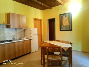 a kitchen with a table and a white refrigerator at Le Terrazze di Martina in Nicotera