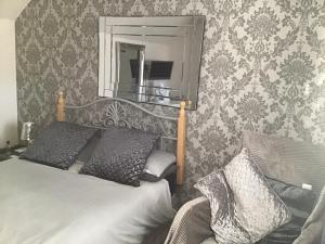 um quarto com uma cama, um espelho e uma cadeira em No.9 em Inverness