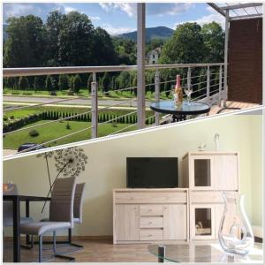 a living room with a balcony with a television and a table at LuxApartament 1 - z widokiem i garażem w nowym Zeta Park in Ustroń