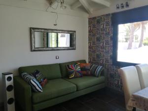 ein Wohnzimmer mit einem grünen Sofa und einem Spiegel in der Unterkunft THE WHITE HOUSE with Pool - Playa Blanca in Playa Blanca