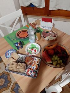 a table with a tray of food and a plate of fruit at B & B Il Mirto 2 in SantʼAntìoco