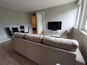 a living room with a couch and a flat screen tv at Leilighet i Espeland in Bergen