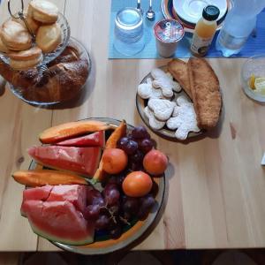una mesa con una bandeja de frutas y hortalizas y pan en B & B Il Mirto 2, en SantʼAntìoco