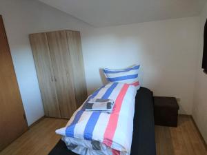 a bedroom with a bed with a striped comforter at An der grünen Donau - Ferienwohnung, wir bieten keine Parkplätze, Verpflegung oder Tücher an, Parken gegenüber auf der Straßenseite möglich in Immendingen