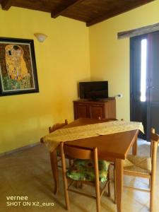 a dining room with a table and a tv at Le Terrazze di Martina in Nicotera