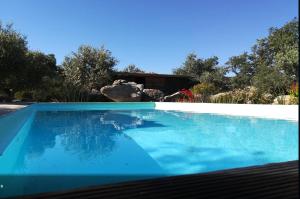 una piscina de agua azul frente a una casa en Monte das Mariolas en Castelo de Vide