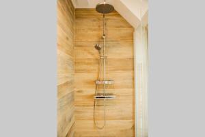 y baño con ducha y pared de madera. en l'Atelier du menuisier, en Amboise