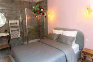 1 dormitorio con cama y ducha en l'Atelier du menuisier, en Amboise