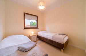 2 łóżka w sypialni z lustrem i oknem w obiekcie Gray House Apartamenty Dziwnówek w Dziwnówku