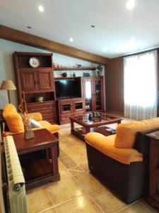 Oto的住宿－Casa Rural O´LIENO，客厅配有沙发和桌子
