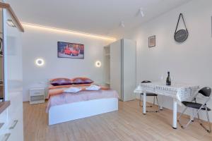 a white bedroom with a bed and a desk at Apartment light in Pula in Pula