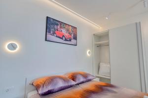 a bedroom with a bed with pillows and a picture on the wall at Apartment light in Pula in Pula