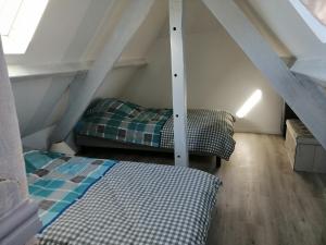 a attic room with a bed and a couch at Gîte Les Mirabelles Calme et Reposant in Vieux-Pont