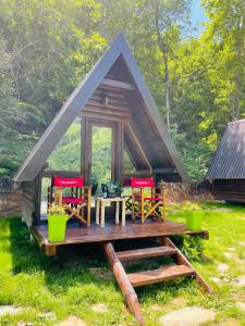 a tent with chairs and a table in the grass at Holiday bungalows Pajkovir in Kolašin