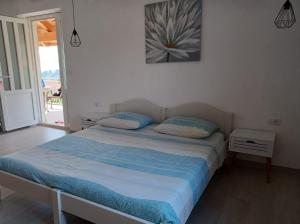 1 cama con 2 almohadas y una foto en la pared en Apartment Grace Cavtat - SEA VIEW, en Cavtat