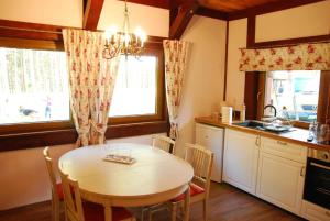 a kitchen with a table and chairs in a kitchen at Chatka nad jeziorem in Studzienice