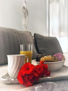 a table with a bowl of donuts and a cup of orange juice at Μaria's flats in Tolo +10 photos