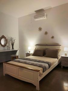 a bedroom with a large bed and a fan at Μaria's flats in Tolo