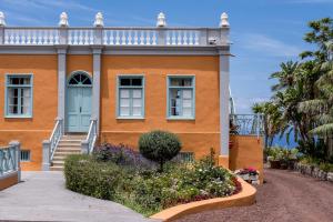 een oranje huis met een blauwe deur en bloemen bij Finca el Patio in Los Realejos