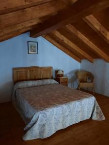 ein Schlafzimmer mit einem Bett in einem Zimmer mit Holzdecken in der Unterkunft Vv LOS SENDEROS FONTANALES in Moya