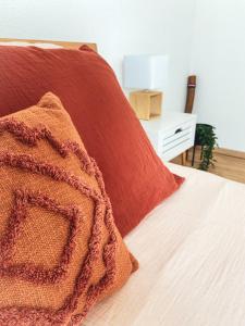 a bed with a red blanket and a white night stand at La Araucania, 2 personnes - WIFI in Rombach-le-Franc