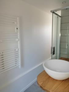 La salle de bains est pourvue d'un grand lavabo blanc sur un comptoir en bois. dans l'établissement Gîte Les Mirabelles Calme et Reposant, à Vieux-Pont