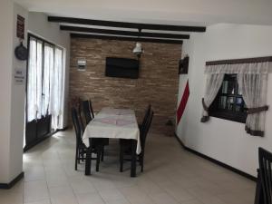 une salle à manger avec une table, des chaises et une télévision dans l'établissement Pensiunea Rustic, à Borşa