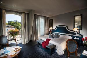 een hotelkamer met een groot bed en een balkon bij Hotel Bristol Salzburg in Salzburg
