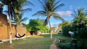 uma rede num quintal com duas palmeiras em Pousada Mar de vênus em Fernando de Noronha