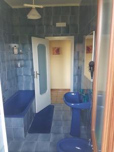 トッレ・デル・グレーコにあるB&B Villa Colombaの青いバスルーム(バスタブ、シンク付)