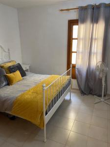 a bedroom with a bed with a yellow blanket and a window at Caletaparaiso110 in Costa de Antigua