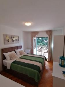 a bedroom with a bed and a large window at Apartment Borovi with terrace and parking Podaca in Podaca +30 photos
