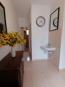 La salle de bains est pourvue d'un lavabo et d'un vase orné de fleurs jaunes. dans l'établissement Apartment Borovi with terrace and parking Podaca, à Podaca