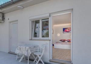 a white room with a table and a bed at Apartment light in Pula in Pula