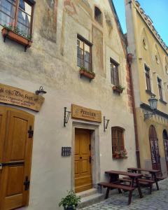 un edificio con due tavoli da picnic di fronte di Hotel Svambersky dum a Cesky Krumlov
