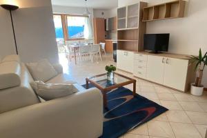 a living room with a white couch and a table at Mountain&Lake Apartment - CIPAT: 022104-AT-849776 in Levico Terme