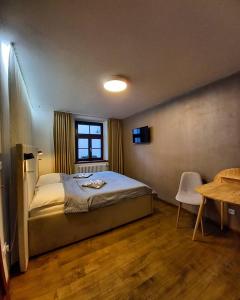 チェスキー・クルムロフにあるホテル スヴァンベルスキー ドゥムのベッドルーム1室(ベッド1台、テーブル、窓付)