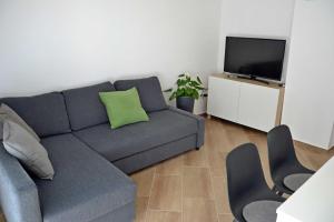 a living room with a couch and a flat screen tv at Fanni Vendégház in Dombóvár