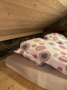 a bed with two pillows on it in a attic at Gróthusið in Sørvágur