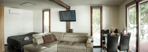 a living room with a couch and a flat screen tv at Golden Beach Apartment in Chlʼaba