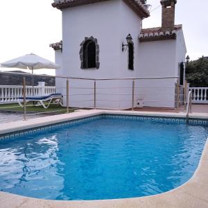 a swimming pool in front of a white house at Villa Las Encinas COSTA DEL SOL in Torrox