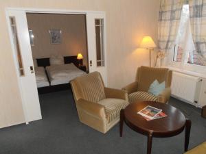 Habitación de hotel con cama, mesa y sillas en Hotel am Deister, en Barsinghausen