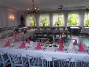 una larga mesa con servilletas rosas con árboles de Navidad en Hotel am Deister, en Barsinghausen